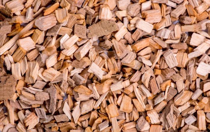 Beispielfoto: Hackschnitzel aus hellem Holz, dicht nebeneinander liegend.